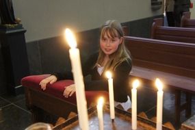 girl stands in the church for the candles