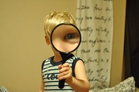 child play with magnifying glass