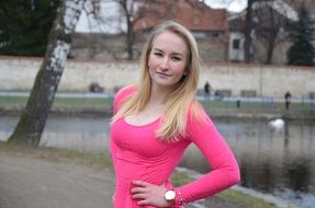 blonde girl in a pink jacket in the park