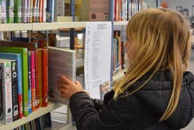 girl is taking a book in the library