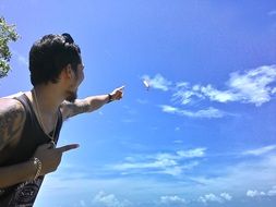 man points his finger at the sky