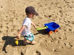 baby playing in the sand on a sunny day