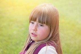 little girl with long hair outdoors on a sunny day