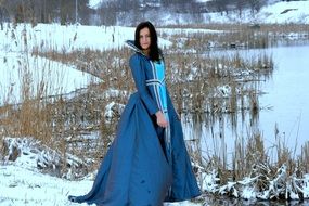 princess in a blue dress on a background of nice snowy nature