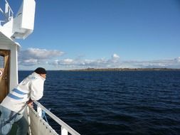 man sailor on a fishing boat admires the Scandinavian nature