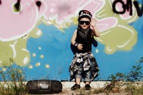 child hip-hop waving hand on a background of graffiti