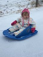 child sledding on a hill