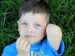 boy is lying on the grass