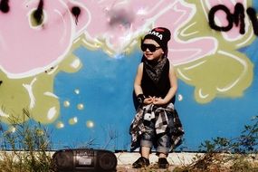 child dressed in a hip-hop style on a background of graffiti