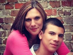 portrait of mother and son near a brick wall