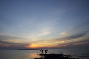 people on the ocean during sunset