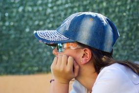 girl in a cap and glasses in the summer