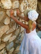 a girl in a white dress near the wall