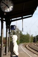 man on a railway platform waiting for a train