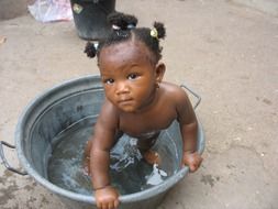 african baby in a bowl of water