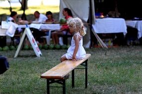 little girl sits on bench