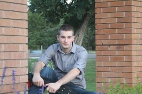 teneydzher near brick wall