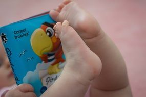 colorful book on the legs of the baby