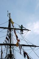 sailor on a mast on a background of gray sky