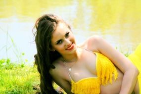 portrait of a beautiful woman in a yellow suit on a background of a nature