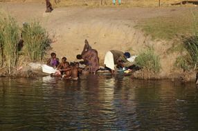 african family wash clothes in the river