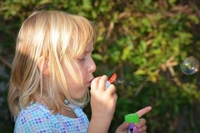 child girl blowing bubbles