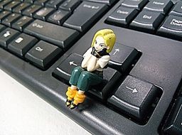 toy girl sits on black keyboard