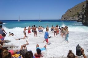 people on beach at rocky coastline