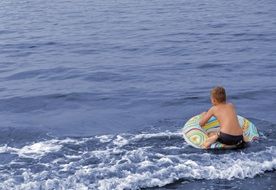 child on a swimming circle on the water