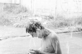 boy under a stream of refreshing water