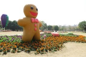 sculpture of a ginger man in a flower bed