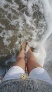girl's legs in the waves of the sea
