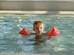 a small child is swimming in the pool