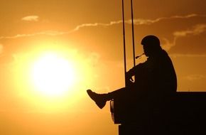 silhouette of a man on a pier during sunset
