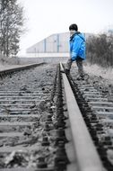 child stands on the railway