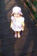 beautiful little caucasian girl stands on bridge