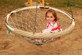 little girl riding on a swing