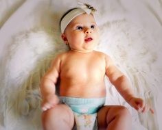 baby in a diaper on a white bedspread