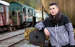 young man at the train carriage on rails