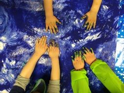hands of children painting with paints