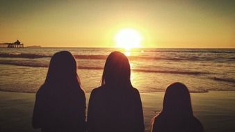 silhouettes of three girls at sunset
