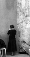 woman is praying at the wall in Jerusalem