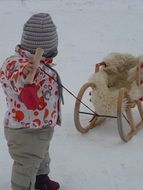 child pulling winter sledge