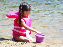 child playing on the beach by the water