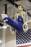 male gymnast doing exercise on rings