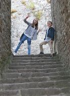 caucasian boy and girl playing on aged stone stairs