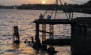 people swimming in the lake at sunset