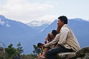 sitting people in view of mountains, himalayas, nepal