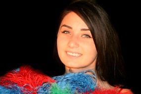 beautiful girl in a clothes with colored feathers