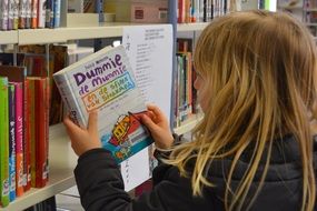 child reading books in a library